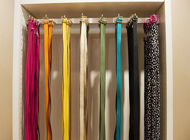 A belt rack with each holding different colored belts.
