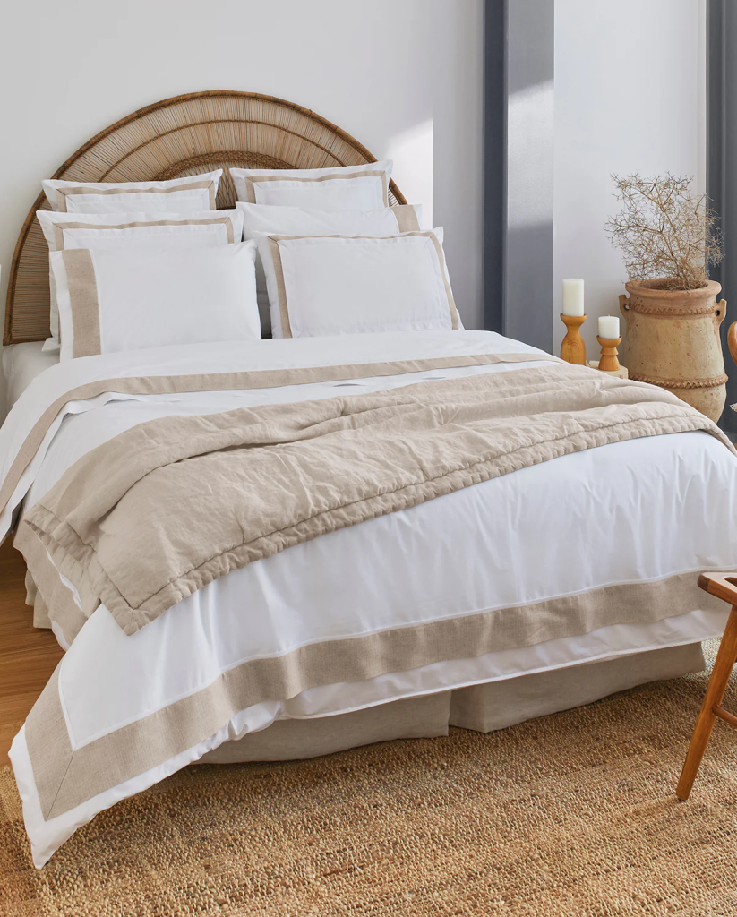 A made bed in a bedroom with wooden/brown accents.