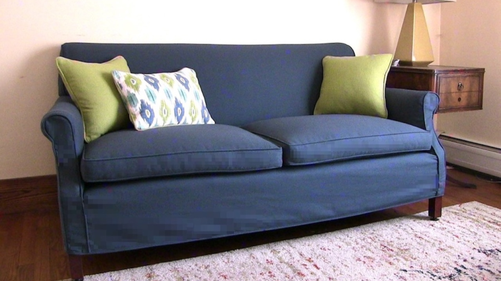 Blue upholstered sofa with green and patterned throw pillows in modern living room
