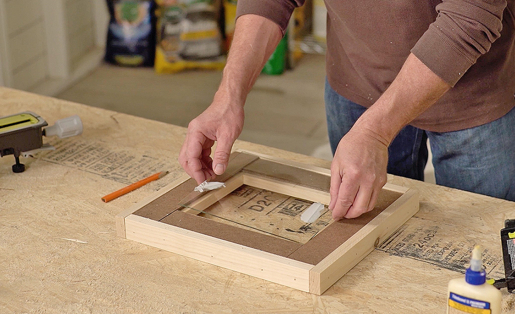 step by step DIY wooden photo frame assembly on workbench