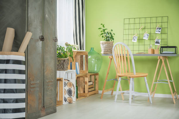 Creative green room with repurposed desk, chair, pallets and metal wardrobe furniture.
