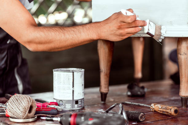 Hands of a man upcycling furniture in a workshop at home. 