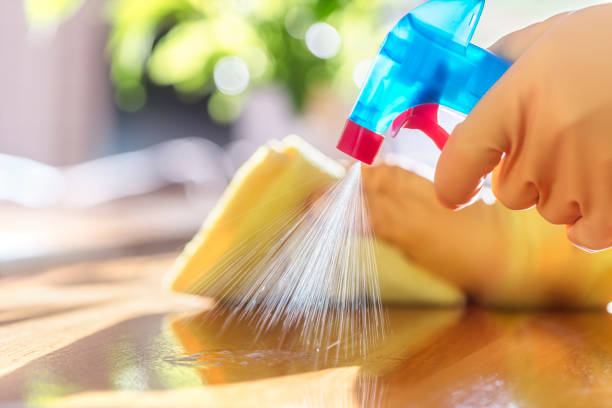 Cleaning a table with spray detergent, rubber gloves and dish cloth.
