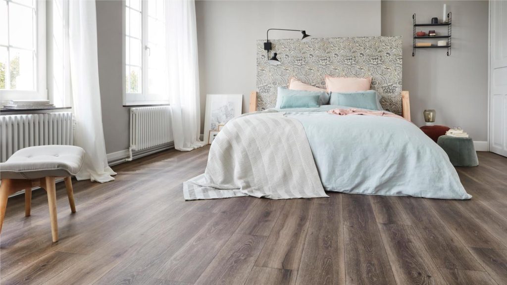 Contemporary bedroom with light laminate flooring and patterned headboard