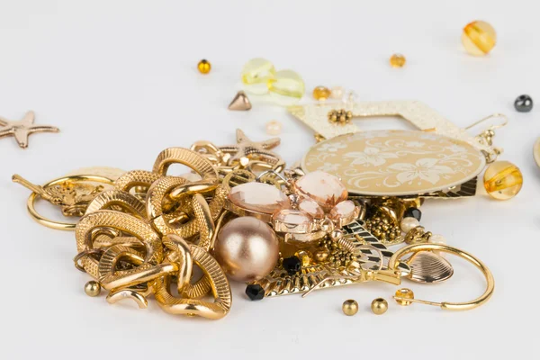 Pile of mixed costume jewelry on white surface