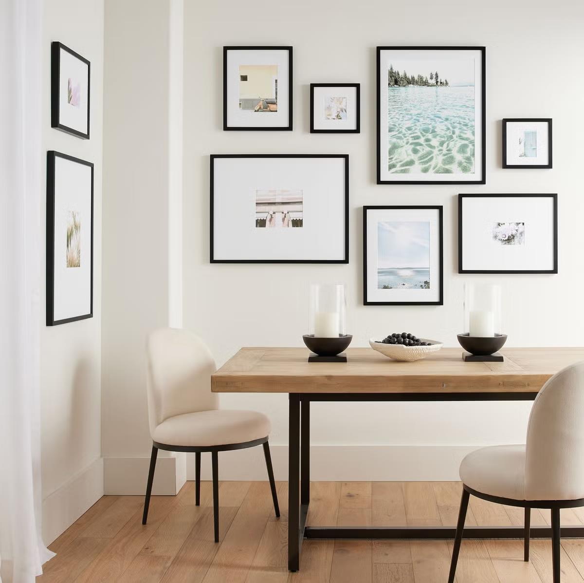 Modern dining area with gallery wall of black frames.