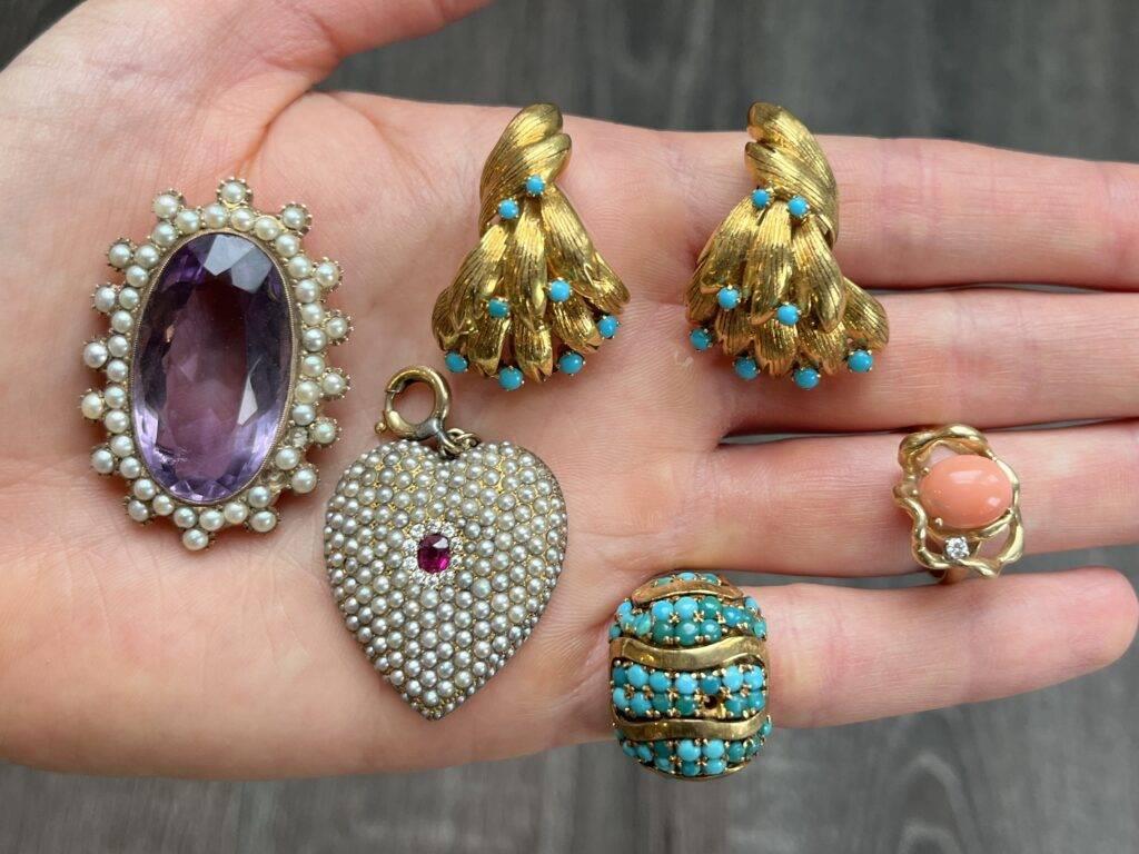 Hand displaying vintage and colorful jewelry