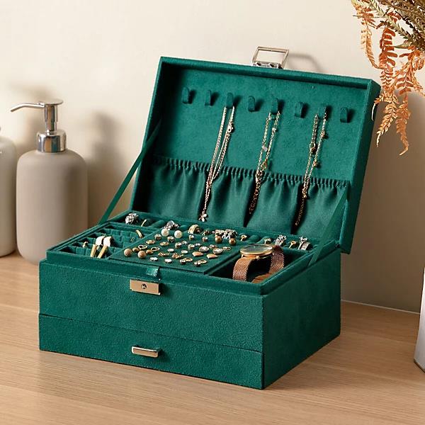 Open green velvet jewelry box on a table