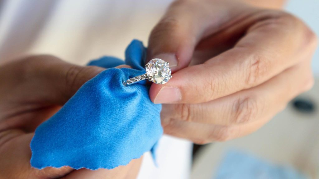 Polishing a diamond ring with blue cloth
