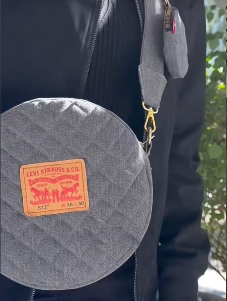 A round quilted denim crossbody bag made from old jeans, adorned with a classic Levi Strauss & Co. leather patch.