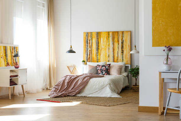 Bright bedroom with yellow abstract art and cozy bedding