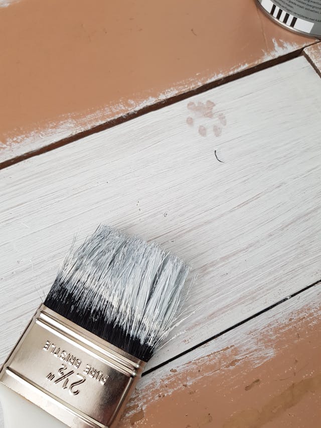 Paintbrush resting on wooden deck.