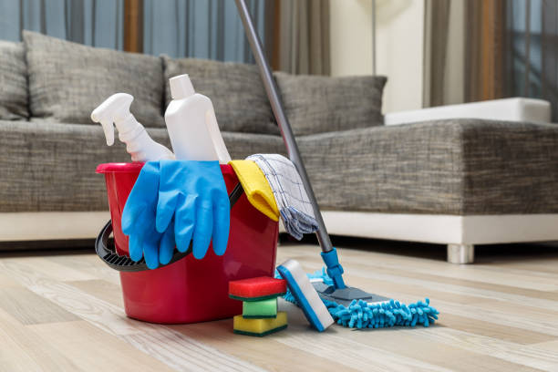 Bucket with sponges, chemicals bottles and mopping stick. Rubber gloves and towel.