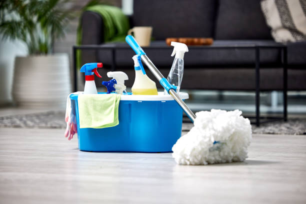 Bucket filled with cleaning supplies next to mop.