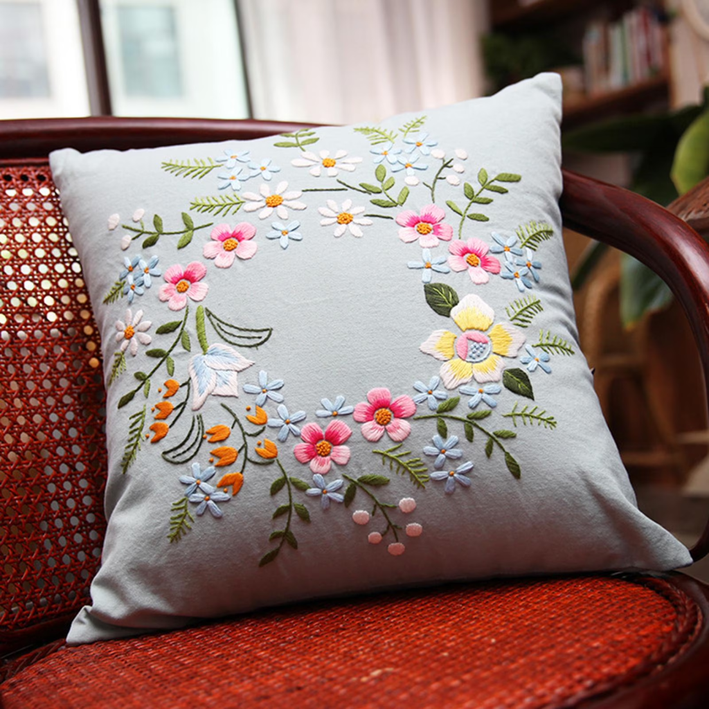 hand embroidered floral throw pillow on wicker chair with elegant handmade cushion cover design