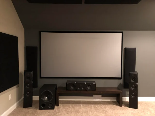 minimalist home theater setup with projection screen subwoofer center speaker and tower speakers