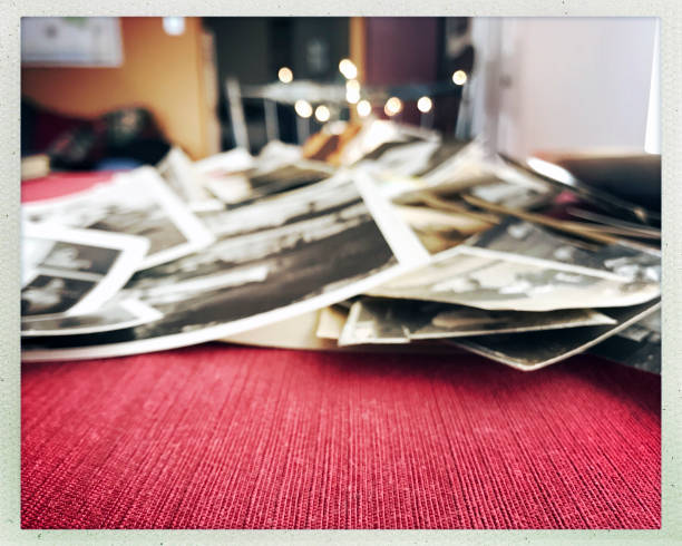 Old black and white photos laying on a red carpet.