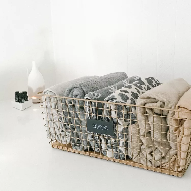 neatly folded scarves in wire basket for organized wardrobe and scarf storage ideas