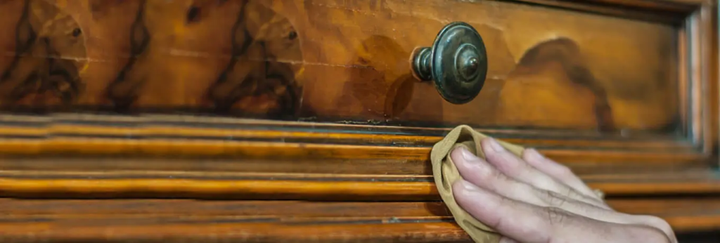 hand cleaning antique wood furniture surface before refinishing and restoration process