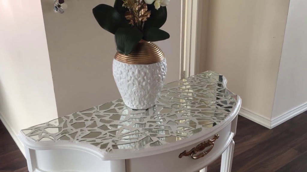 decorative mirrored console table with mosaic glass top and elegant vase centerpiece