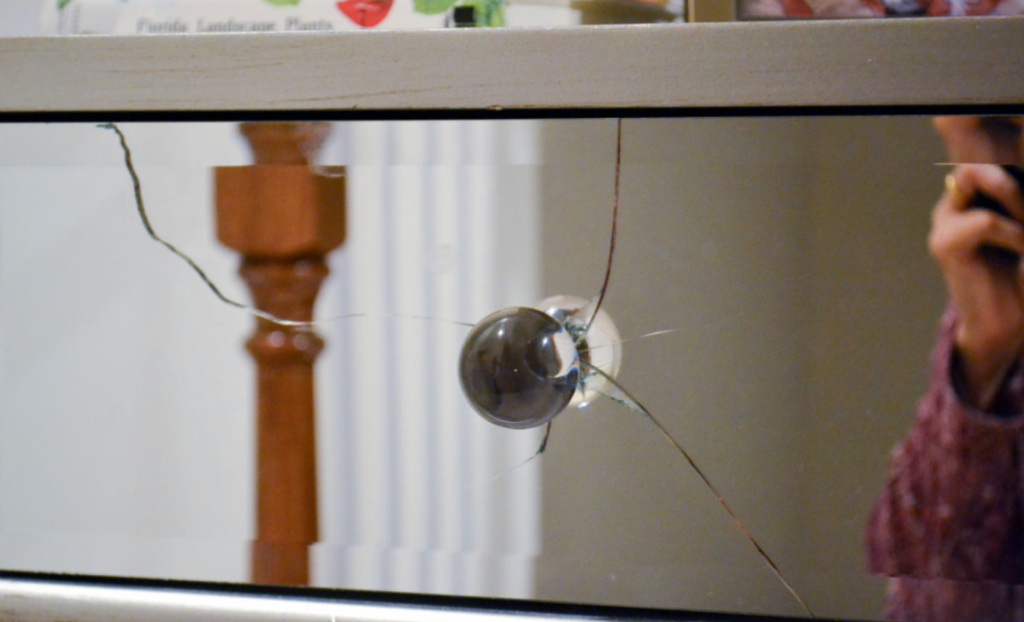 cracked mirrored dresser drawer front showing damaged glass furniture surface repair