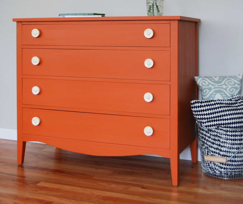 bright orange painted dresser with white knobs for a modern furniture makeover