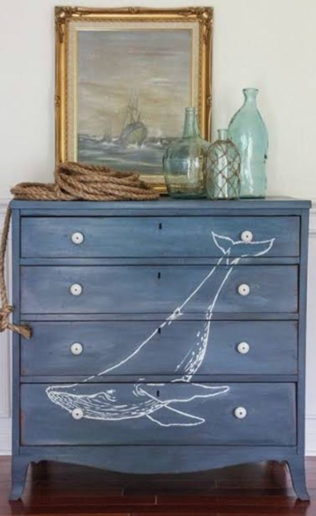 blue coastal dresser featuring hand-painted whale artwork and nautical decorative accessories