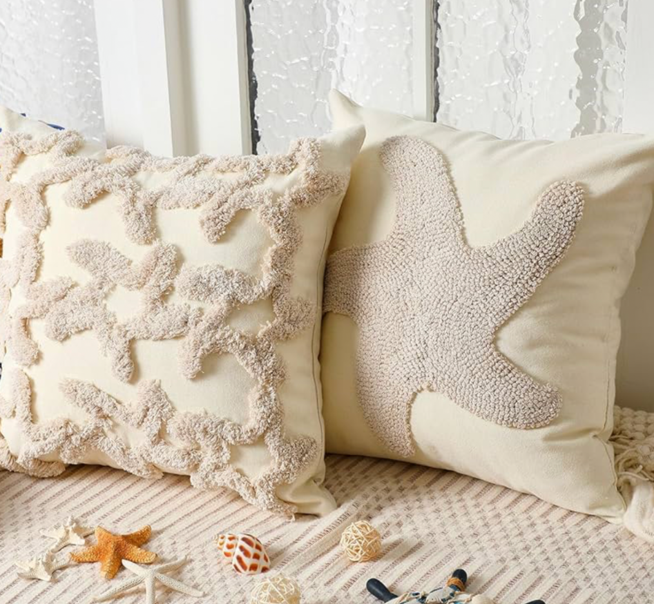 coastal throw pillows with coral and starfish designs on a beach-inspired sofa