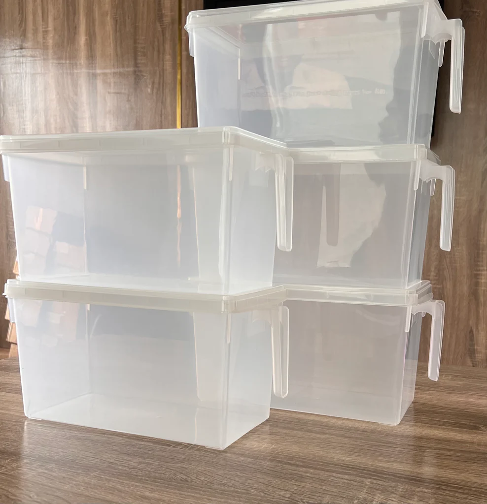 Clear plastic storage bins with lids stacked for kitchen organization and pantry storage solutions