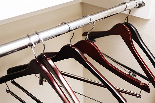 wooden clothes hangers on closet rod for minimalist wardrobe organization