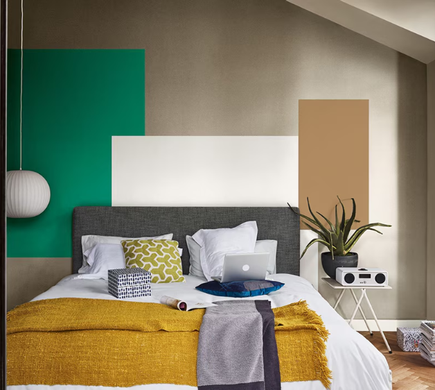 A bedroom displaying blocks of color on the bedroom wall above the bed.