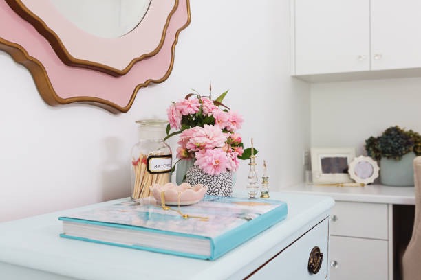 pastel blue dresser styled with flowers books and feminine bedroom decor