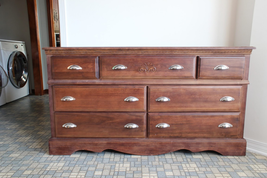 A bulky old set of drawers hitting against a wall.