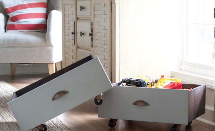 Wheels attached to white drawers with furniture packed in one in a living room.