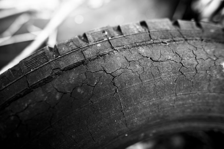 Black and white photo of a heavily cracked tire.