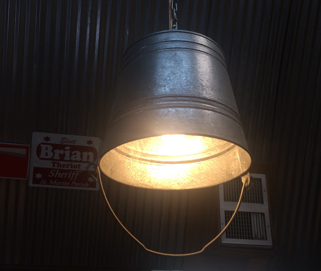 Galvanized metal pan with a light attached in a dim room.