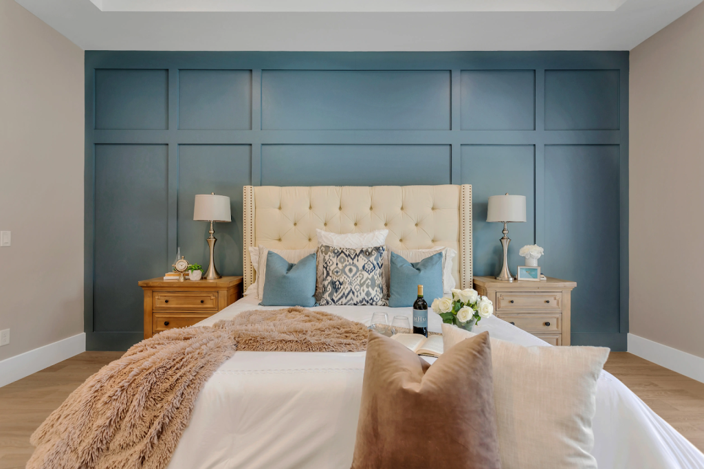 A blue planked accent wall in a bedroom with all other walls and ceiling being off white.