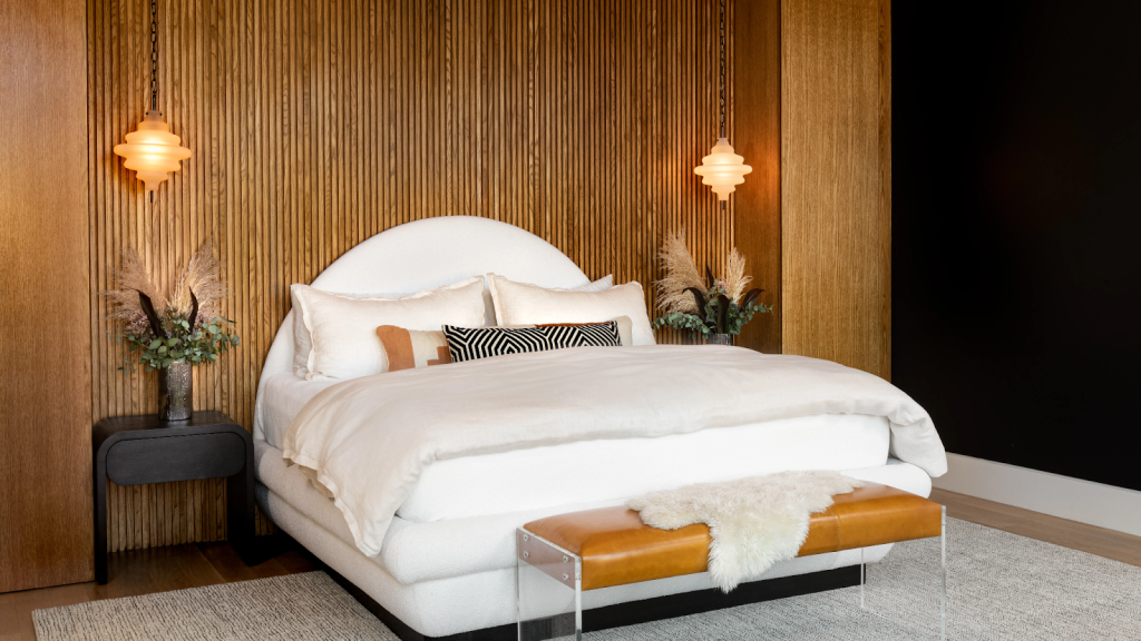 spiral designed lighting hung by a chain from the ceiling beside the bad but above the night stands on with side of it on a wood slat accent wall.
