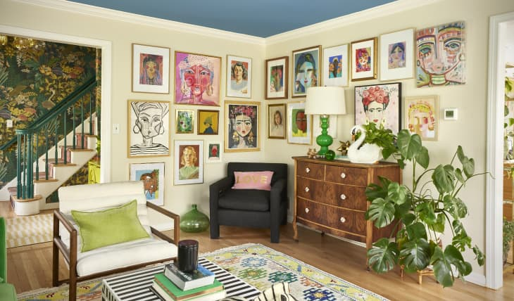 Quirky drawings in various sized frames on the walls of a living room.
