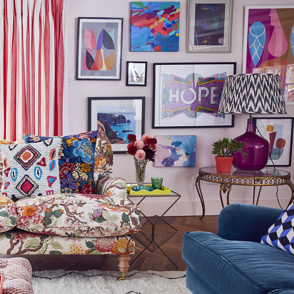 A colorful living room with a gallery of frames holding different art.
