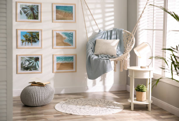 Checkout this stylish room interior with its hanging seat in front of a beachy gallery of wall art