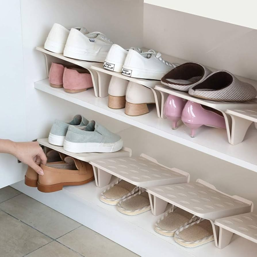 A woman placing shoes in a built in shoe rack.
