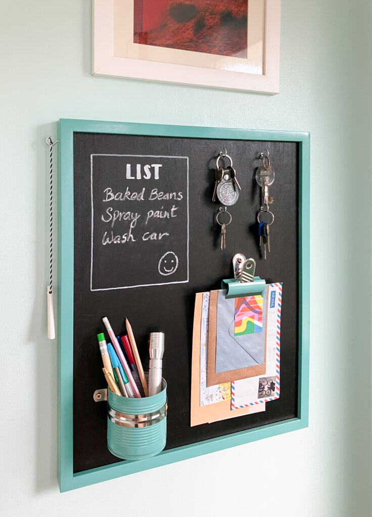 Teal chalkboard with to do list and cupholder as well as key holders.