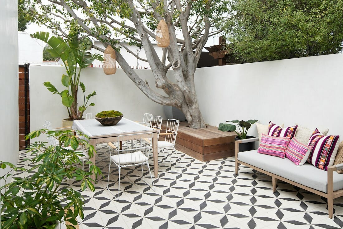A tiled patio decorated with furniture and hanging lights.