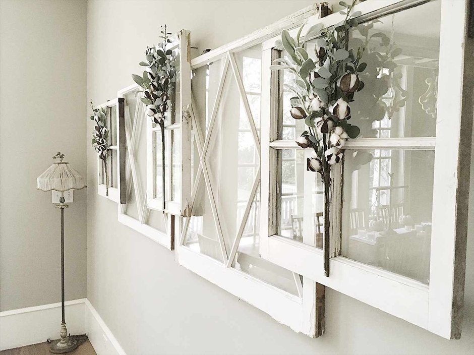 Rustic white window frames decorated with cotton branches for a farmhouse wall display