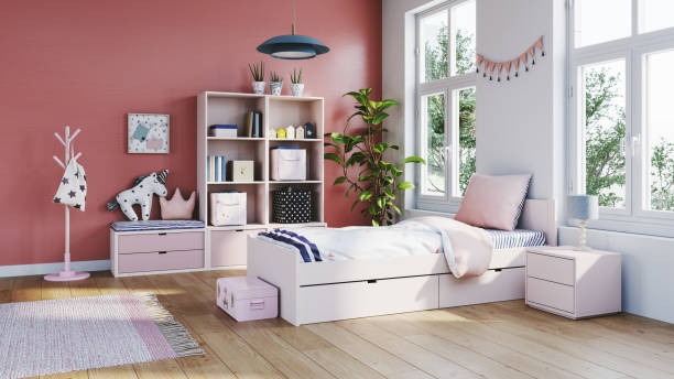 A bright kids’ bedroom with coral walls, a white bed with built-in drawers, toy storage shelves, playful decor, and large windows bringing in natural light.