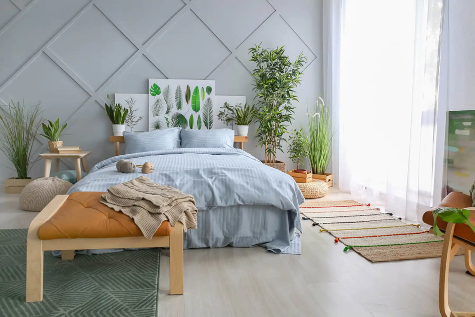 Minimalist bedroom with blue bedding and leaf-themed decor