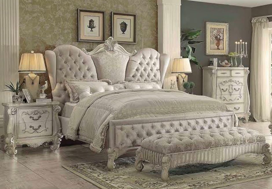Elegant tufted bed with light-colored furniture and soft lighting.