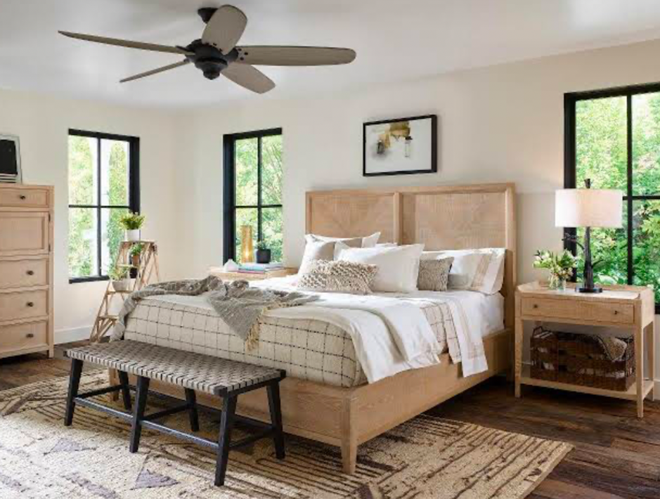 Bright minimal bedroom with wooden furniture, large windows, and ceiling fan.