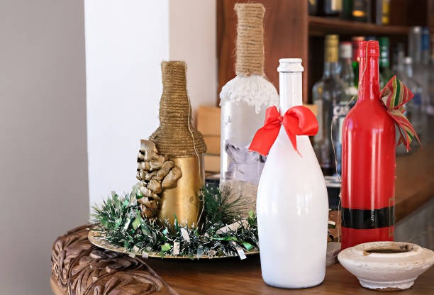 upcycled glass bottles decorated with twine paint and festive bows for christmas decor